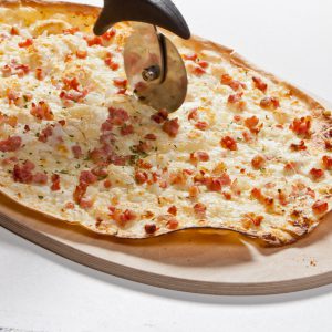 ein Flammkuchen mit einem Pizzaschneider